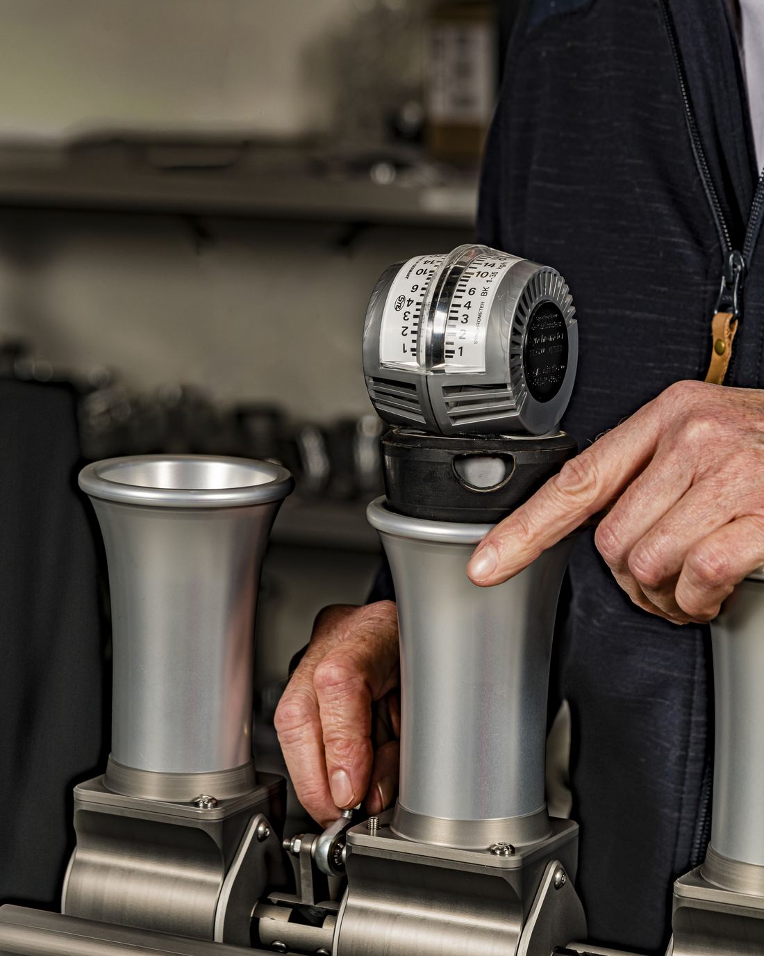 Hands fitting an elliptical roller barrel into a CNC-machined Rennen throttle body
