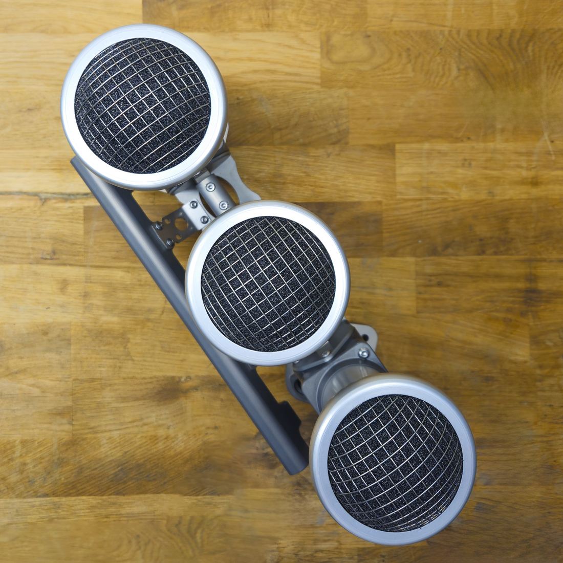 Top-down view of Rennen velocity stacks fitted with mesh filters on a triple throttle body bank