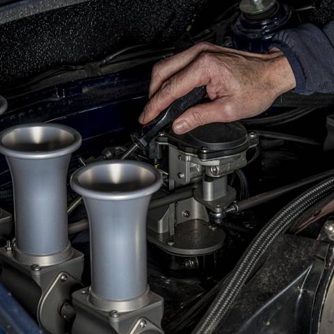 Hand adjusting a Rennen ITB system in the engine bay